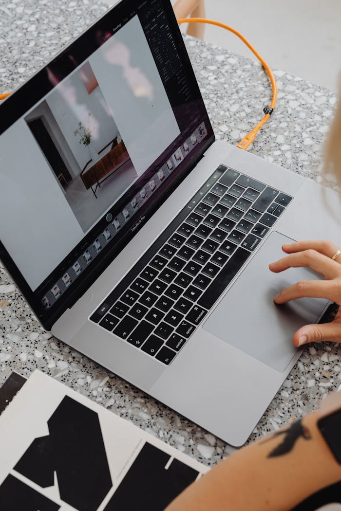 Top view of a person working on a laptop with design materials, ideal for remote work concept.